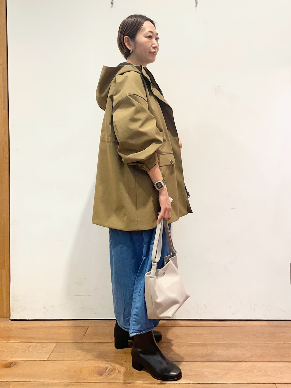 ベージュ系のその他アウター、ブルー系のワンピース、ブラック系のブーツを着用したレディースの秋コーディネートの4枚目の写真