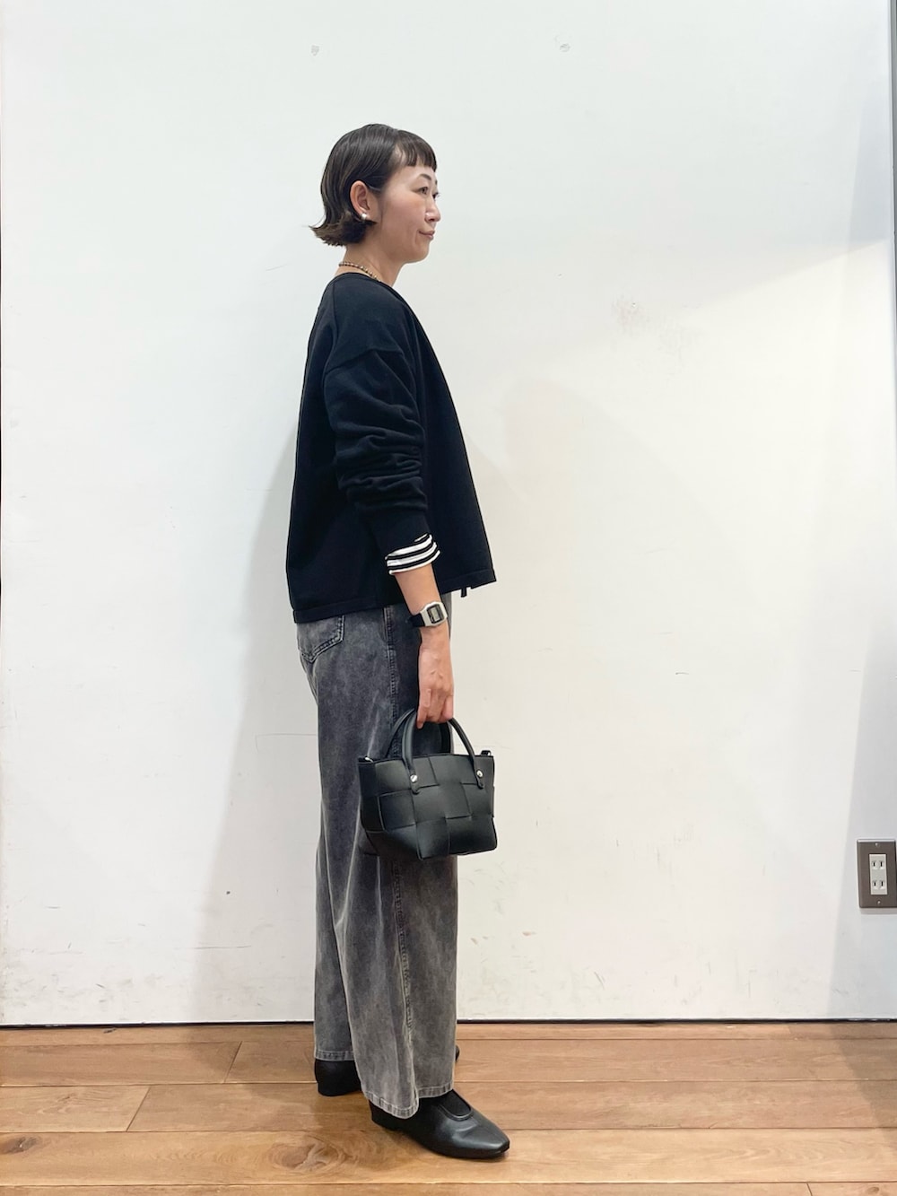 ブラック系のカーディガン/ボレロ、ホワイト系のTシャツ/カットソー、ブラック系のスリッポンを着用したレディースの秋コーディネートの4枚目の写真
