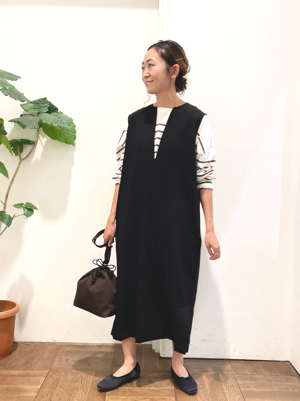 ブラック系のワンピース、ブラウン系のTシャツ/カットソー、ブラウン系のショルダーバッグを着用したレディースの秋コーディネートの3枚目の写真