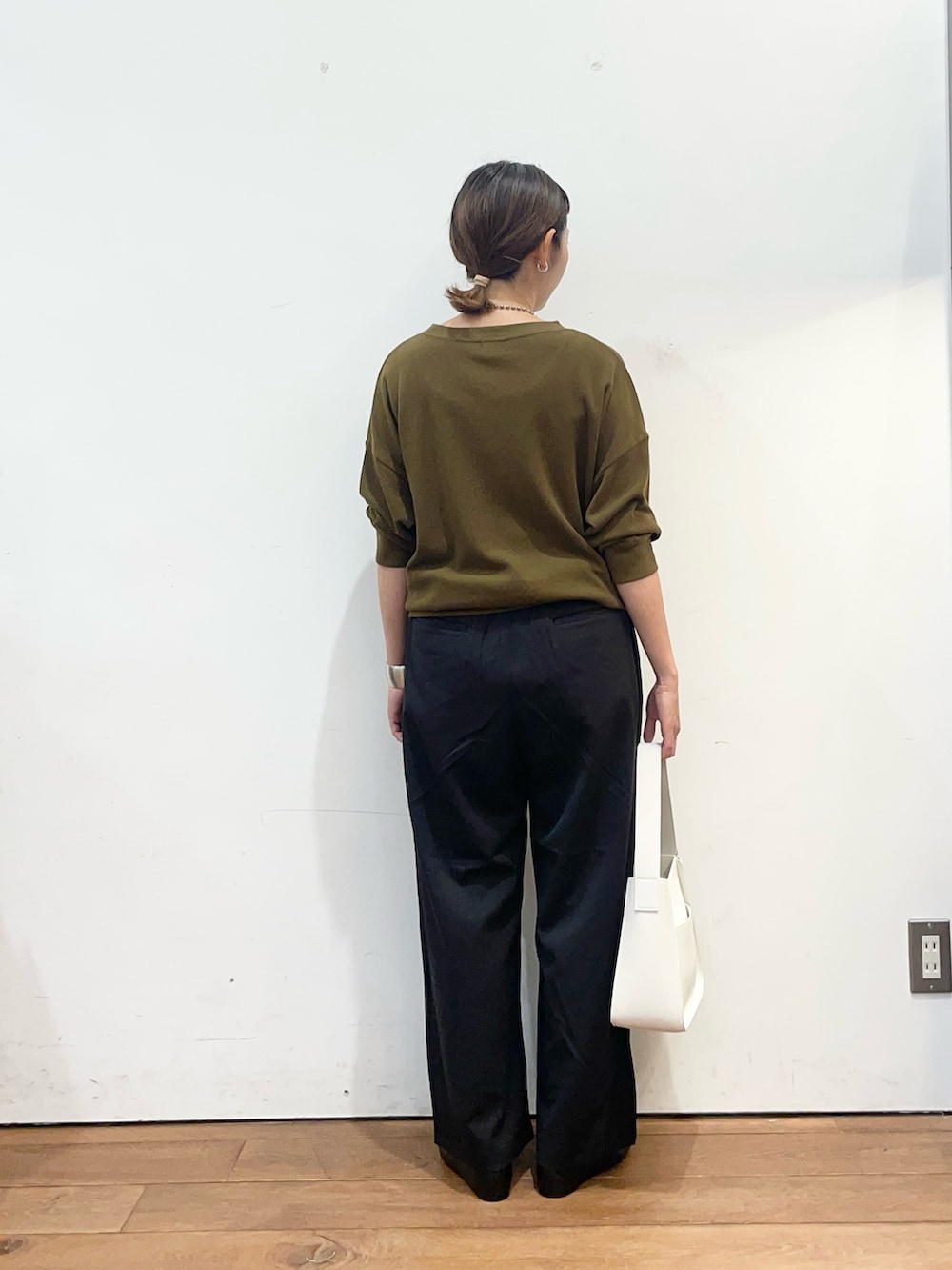 ブラウン系のTシャツ/カットソー、ブラック系のその他パンツ、ホワイト系のハンドバッグを着用したレディースの秋コーディネートの4枚目の写真