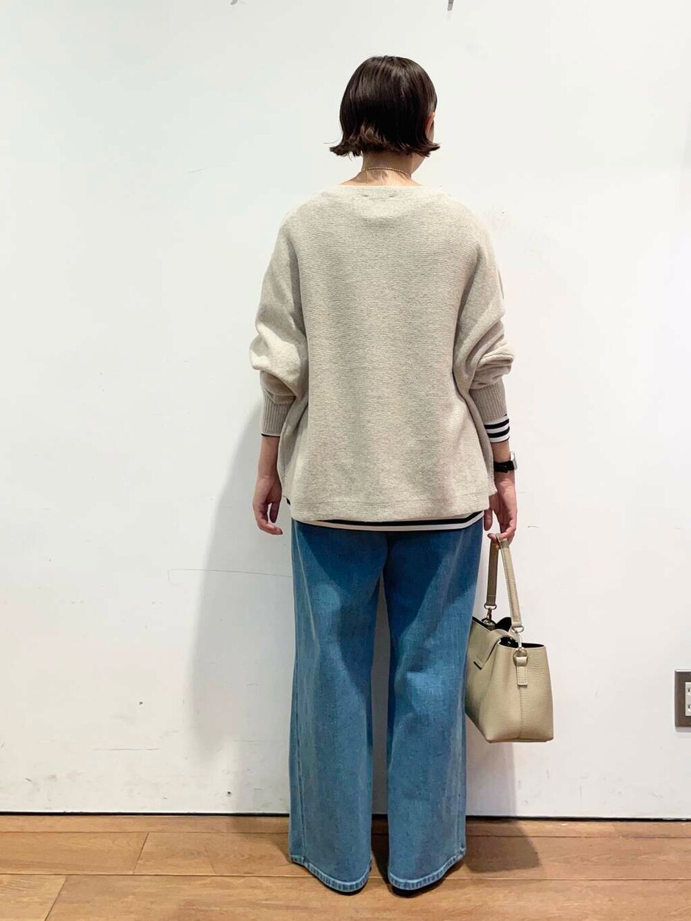 ブラック系のパンプス、ベージュ系のニット/セーター、ベージュ系のショルダーバッグを着用したレディースの秋コーディネートの5枚目の写真