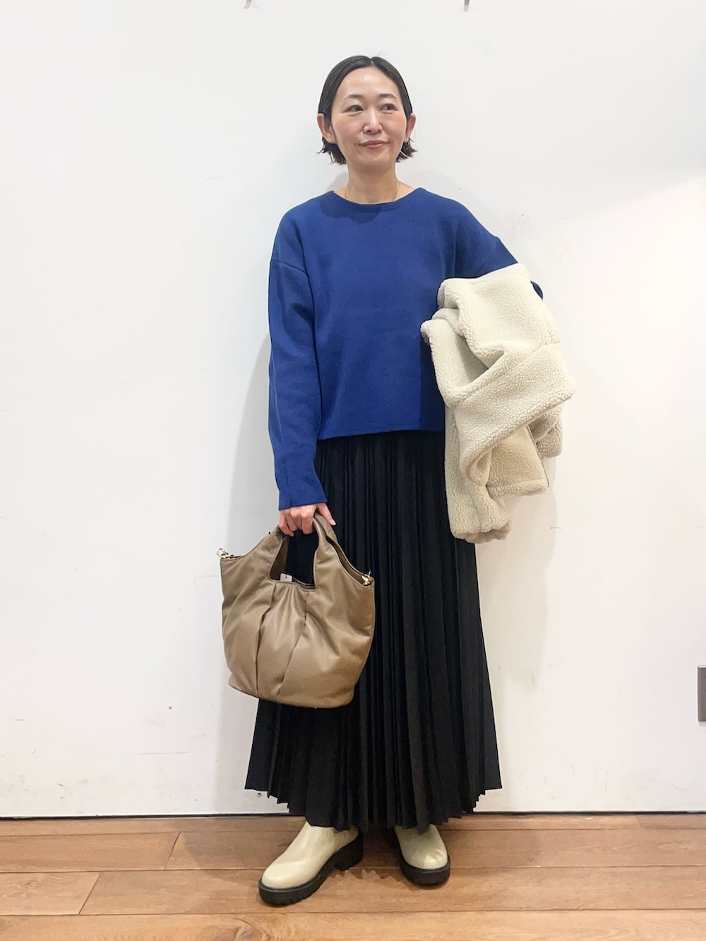 ホワイト系のその他アウター、ブルー系のニット/セーター、ブラック系のスカートを着用したレディースの冬コーディネートの6枚目の写真