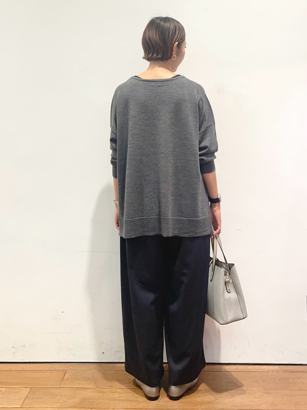グレー系のニット/セーター、ブルー系のその他パンツ、グレー系のトートバッグを着用したレディースの秋コーディネートの6枚目の写真