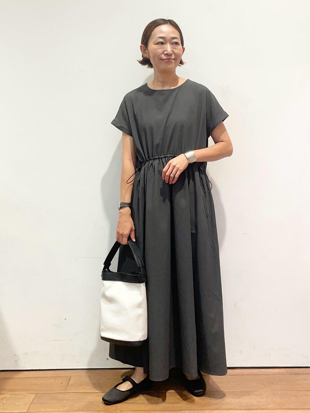 グレー系のワンピース、ブラック系のショルダーバッグを着用したレディースの秋コーディネートの2枚目の写真