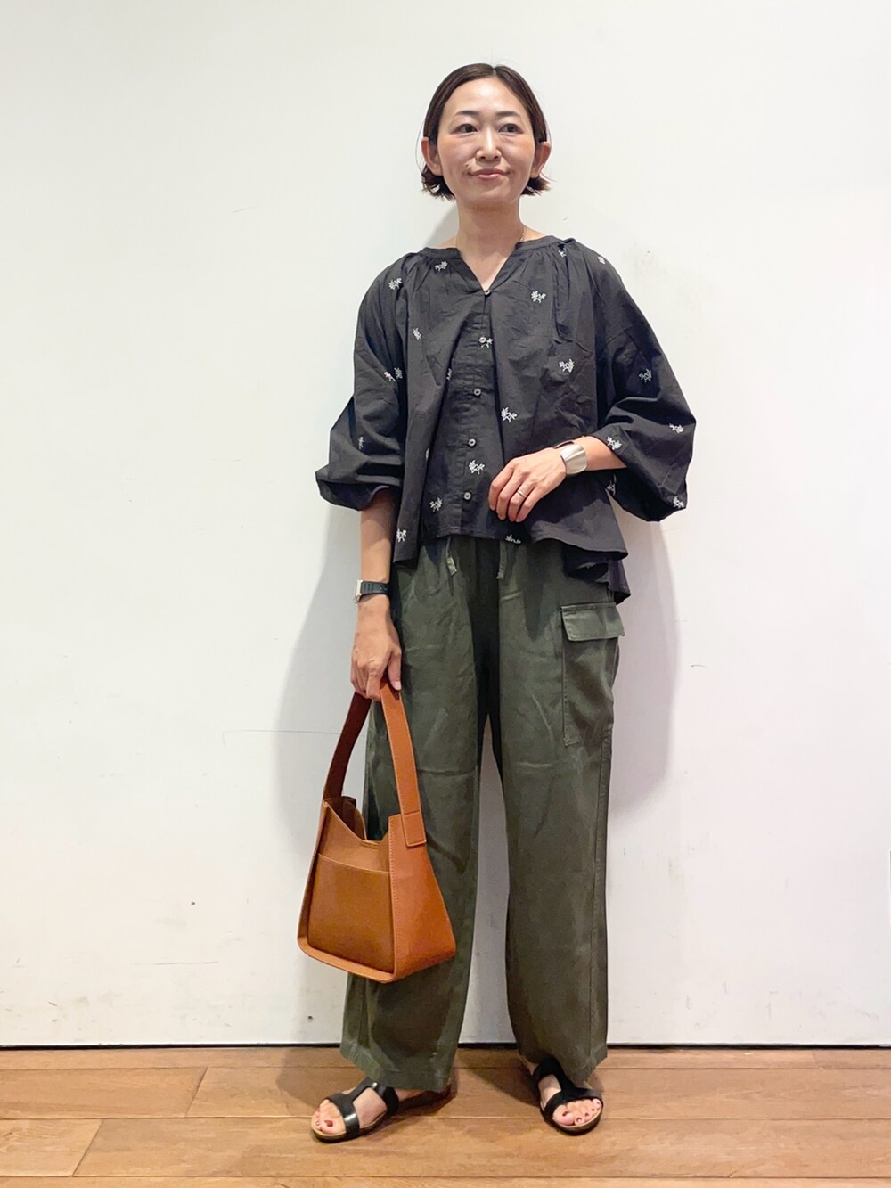 ブラック系のサンダル、グリーン系のその他パンツ、ブラウン系のハンドバッグを着用したレディースの夏コーディネートの2枚目の写真