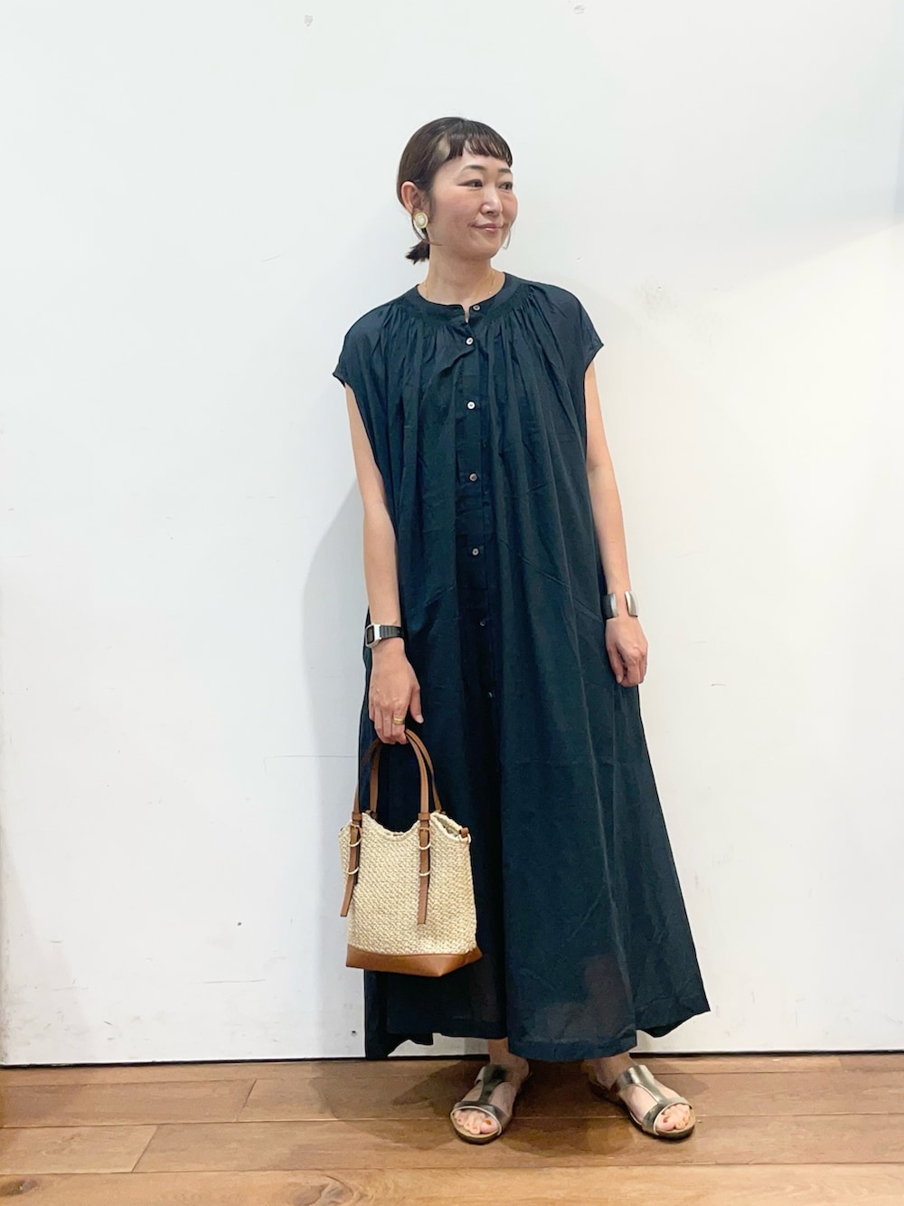 グリーン系のワンピース、イエロー系のショルダーバッグ、ゴールド系のサンダルを着用したレディースの夏コーディネートの2枚目の写真