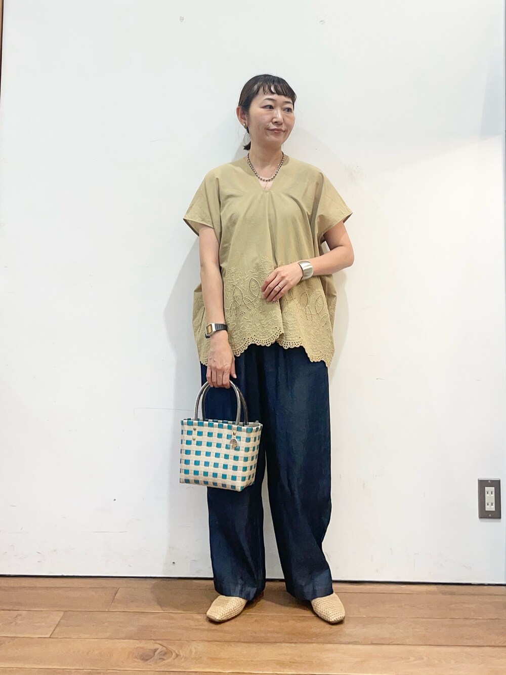 ベージュ系のシャツ/ブラウス、ベージュ系のバレエシューズ、グリーン系のショルダーバッグを着用したレディースの夏コーディネートの3枚目の写真