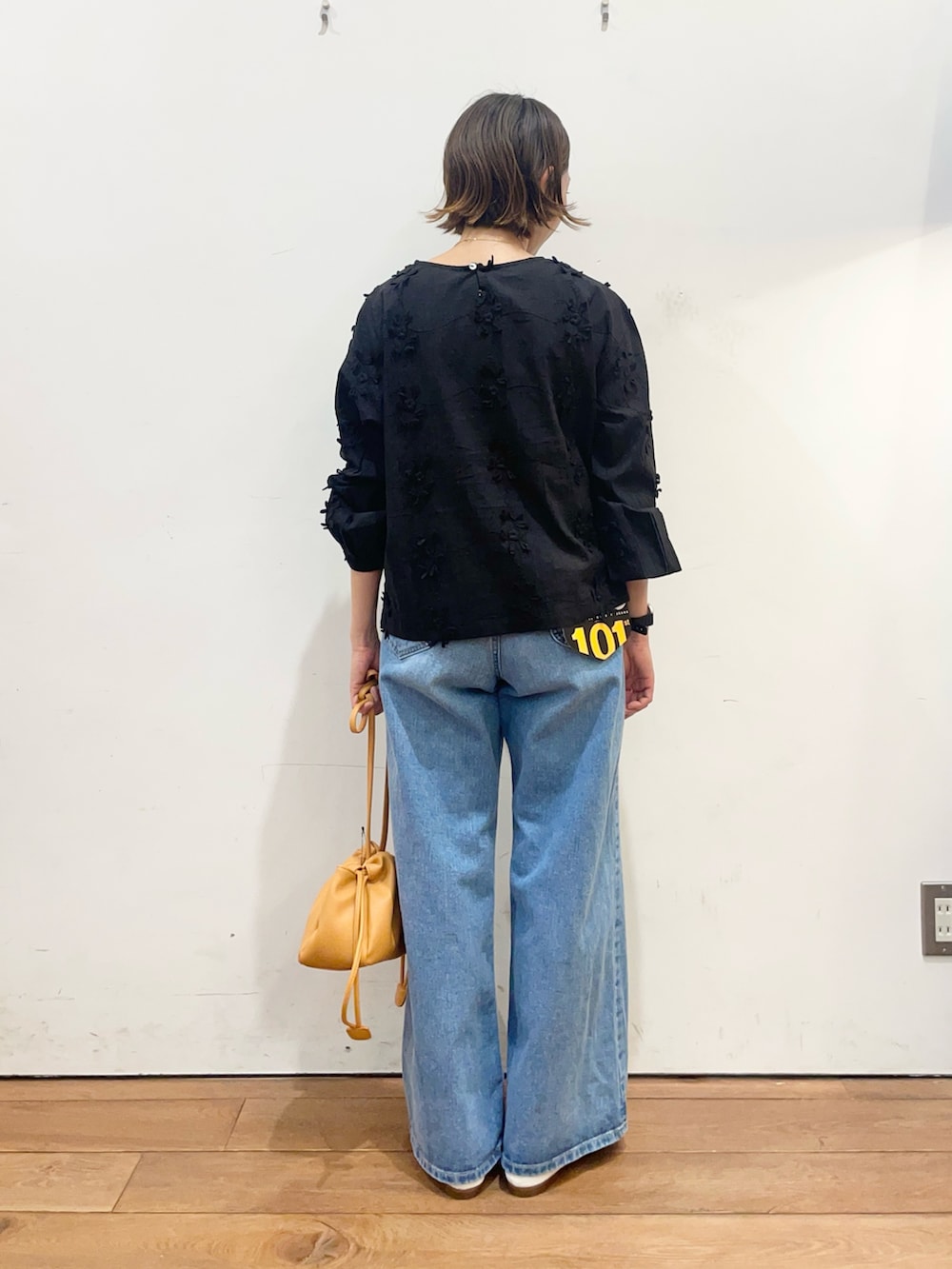 ブラック系のシャツ/ブラウス、ブルー系のデニムパンツ、オレンジ系のショルダーバッグを着用したレディースの冬コーディネートの5枚目の写真