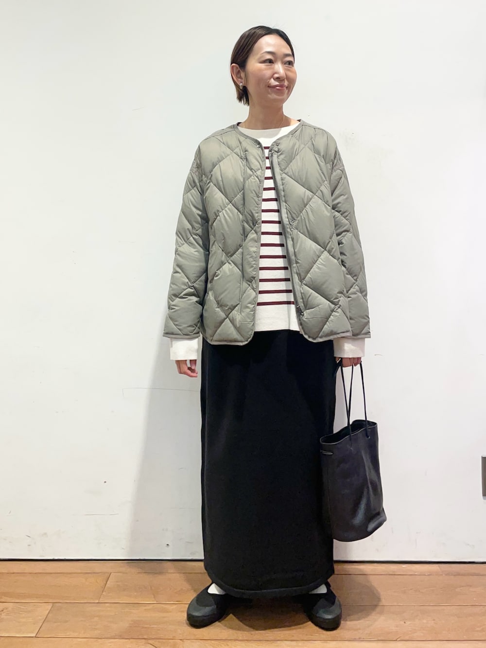 ブラック系のショルダーバッグ、レッド系のニット/セーター、グリーン系のその他アウターを着用したレディースの秋コーディネートの2枚目の写真