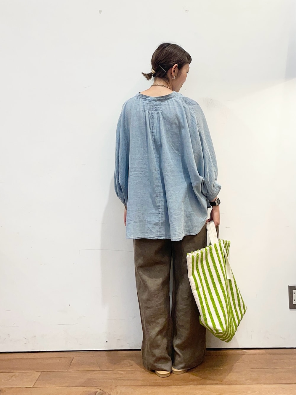 ブルー系のシャツ/ブラウス、グリーン系のトートバッグ、ブラウン系のその他パンツを着用したレディースの夏コーディネートの4枚目の写真