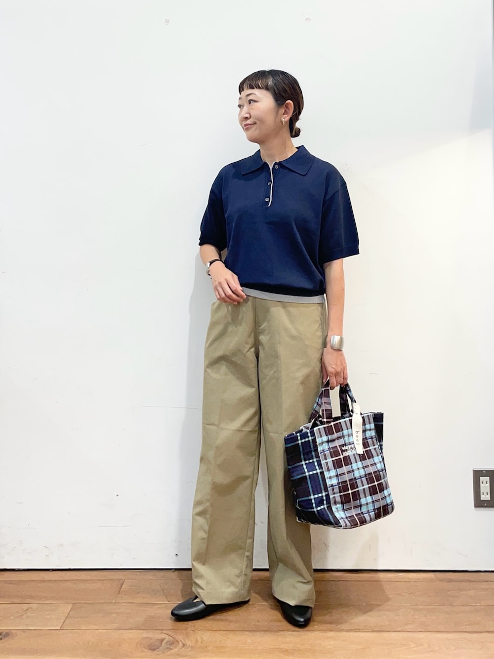 ブルー系のポロシャツ、ベージュ系のその他パンツ、ブラウン系のトートバッグを着用したレディースの秋コーディネートの2枚目の写真