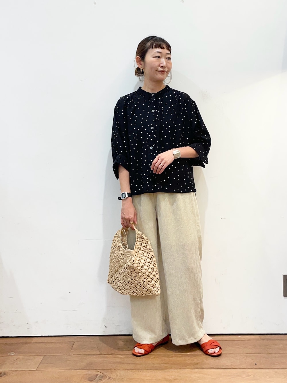 ブラック系のシャツ/ブラウス、ベージュ系のハンドバッグ、ベージュ系のその他パンツを着用したレディースの夏コーディネートの2枚目の写真