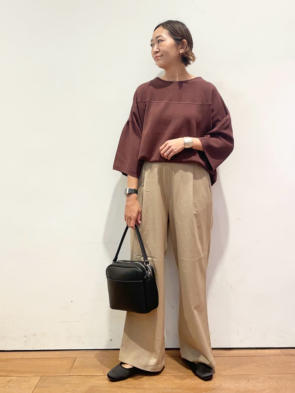 ベージュ系のその他パンツ、ブラウン系のニット/セーター、ブラック系のショルダーバッグを着用したレディースの秋コーディネートの3枚目の写真