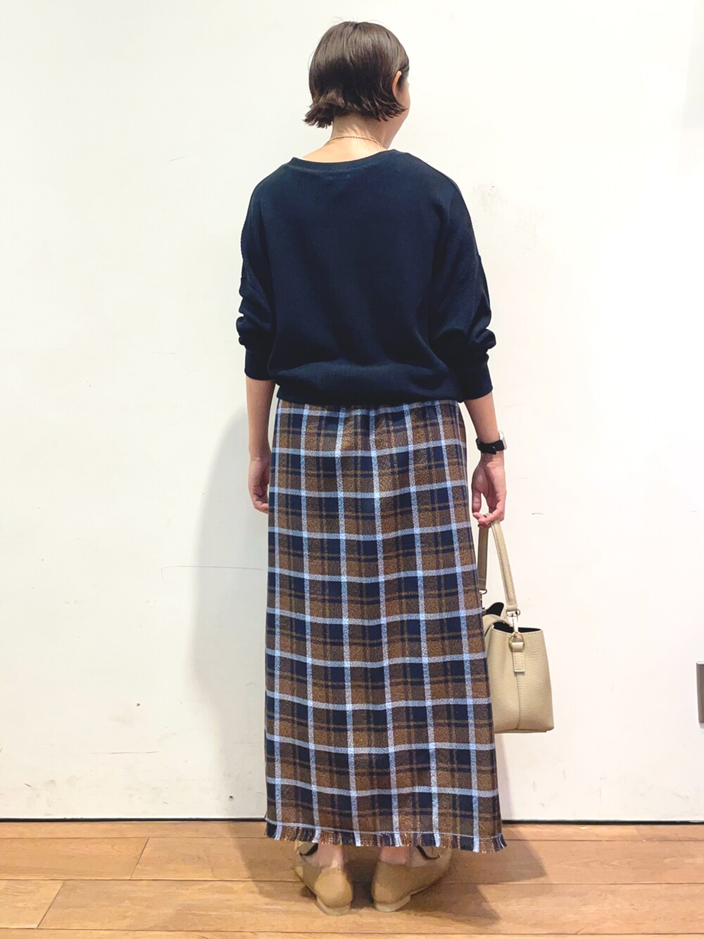 ブルー系のTシャツ/カットソー、ブラウン系のスカート、ベージュ系のローファーを着用したレディースの秋コーディネートの4枚目の写真