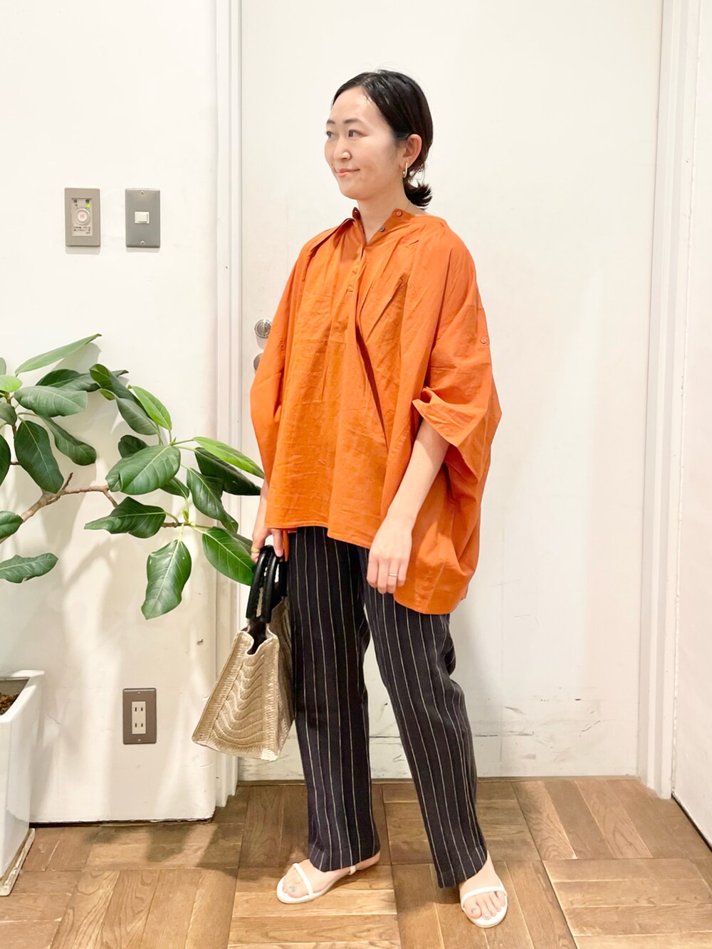 オレンジ系のシャツ/ブラウス、グレー系のその他パンツ、ホワイト系のサンダルを着用したレディースの夏コーディネートの4枚目の写真