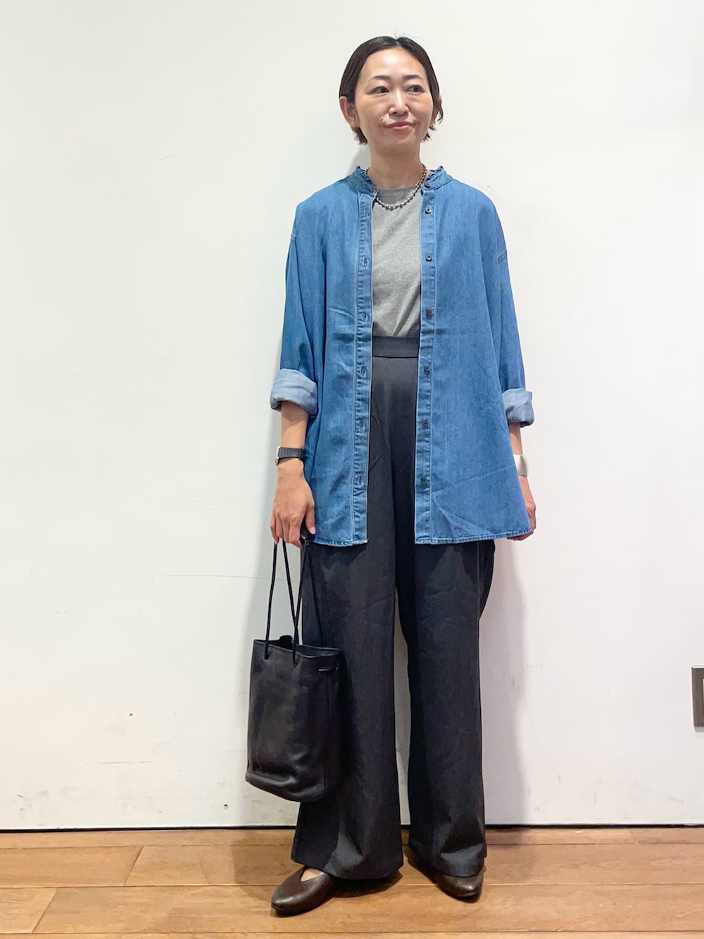 ブルー系のシャツ/ブラウス、ブラウン系のパンプス、グレー系のその他パンツを着用したレディースの秋コーディネートの2枚目の写真