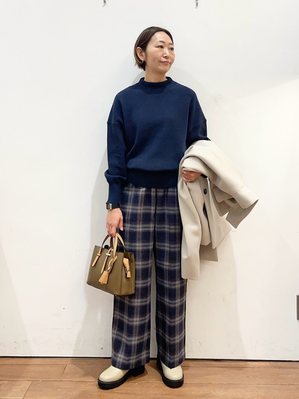 ベージュ系のその他アウター、ブルー系のニット/セーター、ブラウン系のハンドバッグを着用したレディースの冬コーディネートの6枚目の写真