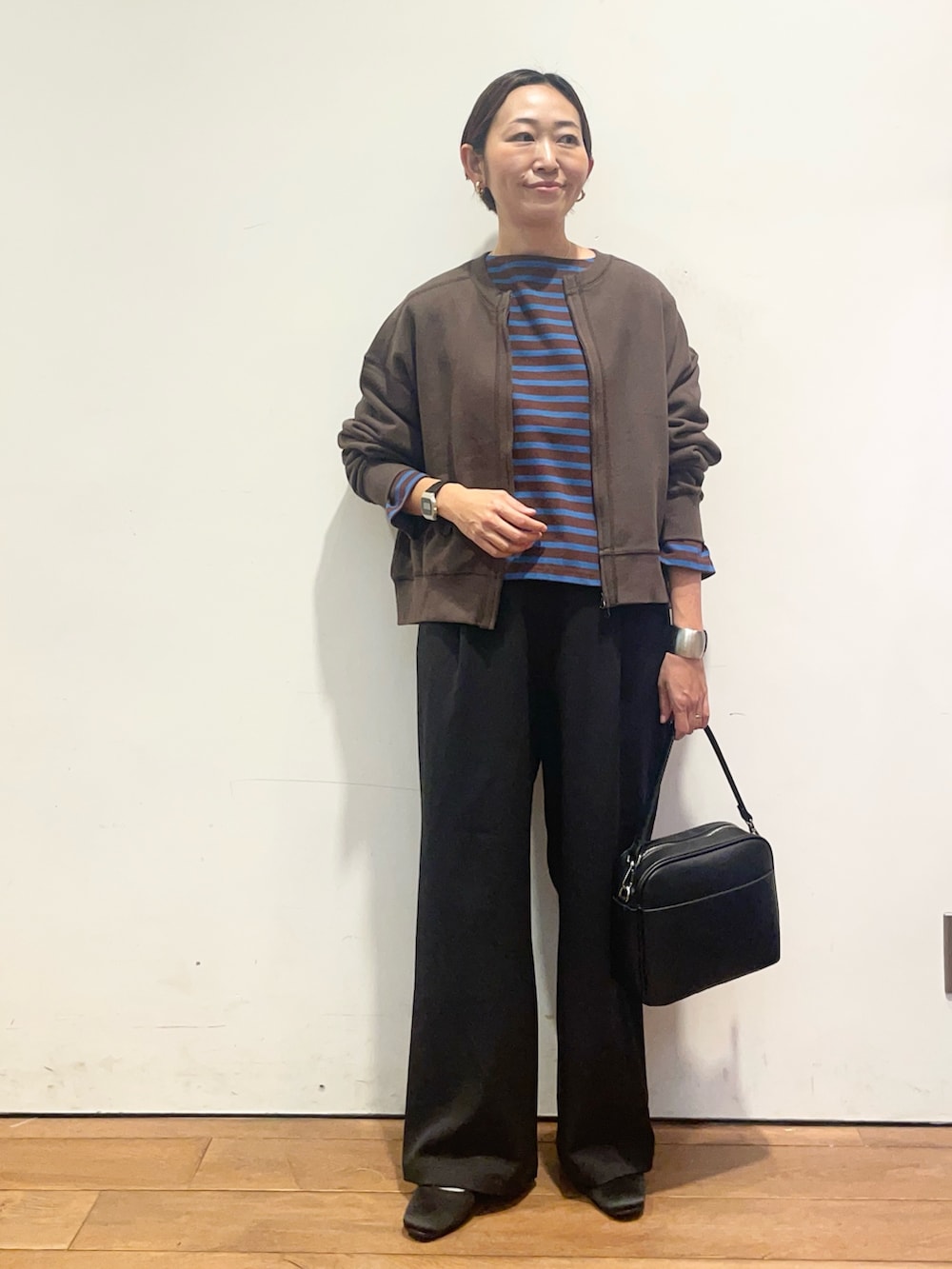 ブラウン系のカーディガン/ボレロ、ブラウン系のTシャツ/カットソー、ブラック系のその他パンツを着用したレディースの秋コーディネートの3枚目の写真