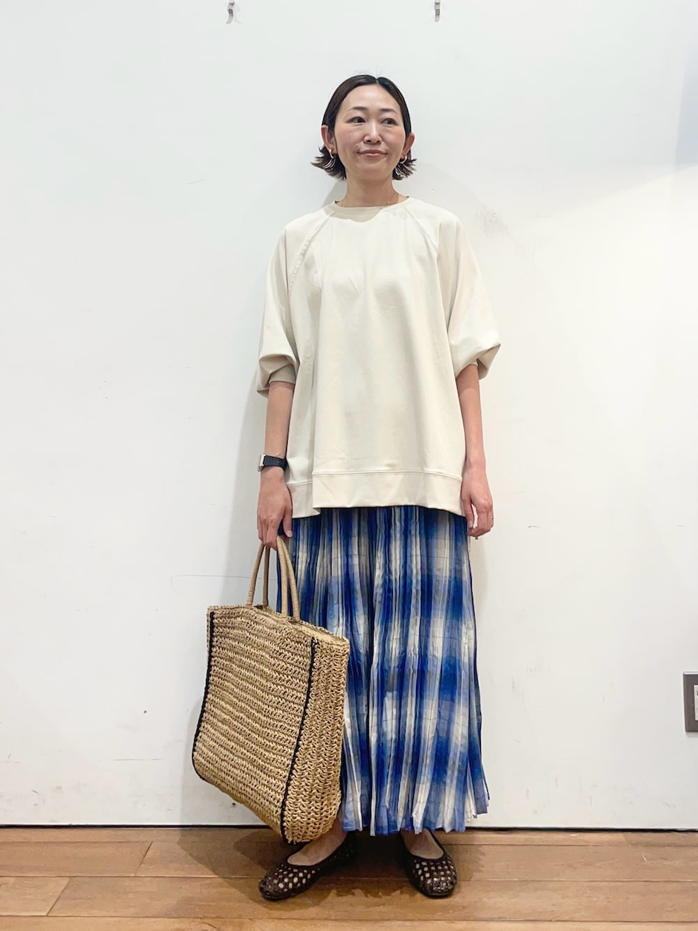 ベージュ系のTシャツ/カットソー、ブルー系のスカート、ブラウン系のサンダルを着用したレディースの春コーディネートの2枚目の写真