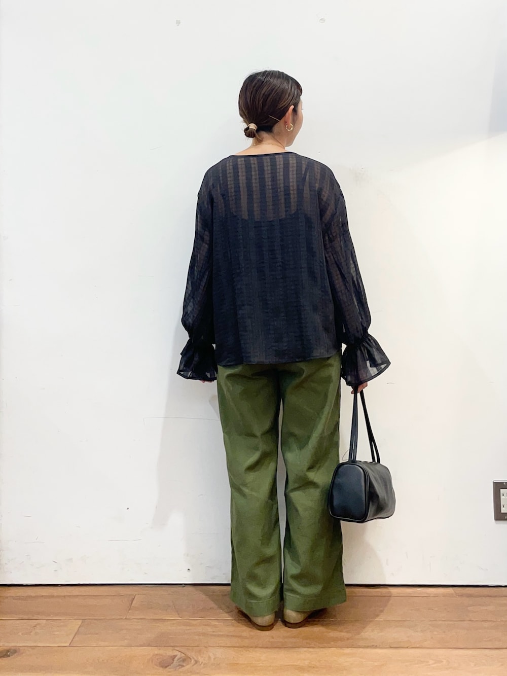 ブラック系のシャツ/ブラウス、グリーン系のその他パンツ、ブラック系のハンドバッグを着用したレディースの秋コーディネートの5枚目の写真