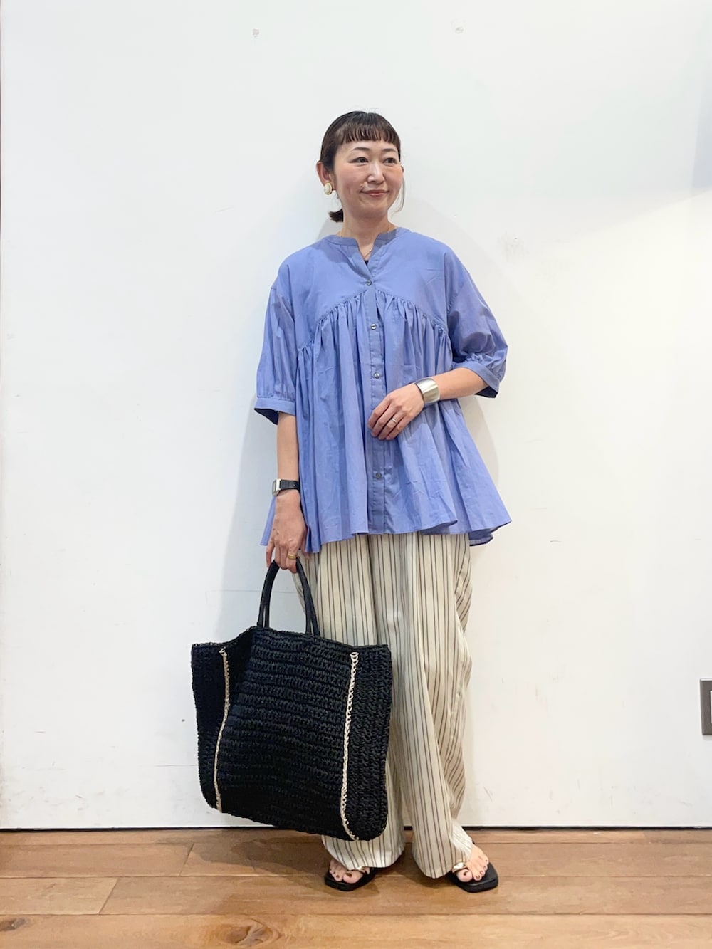 ブルー系のシャツ/ブラウス、ブラック系のサンダル、ベージュ系のその他パンツを着用したレディースの夏コーディネートの2枚目の写真