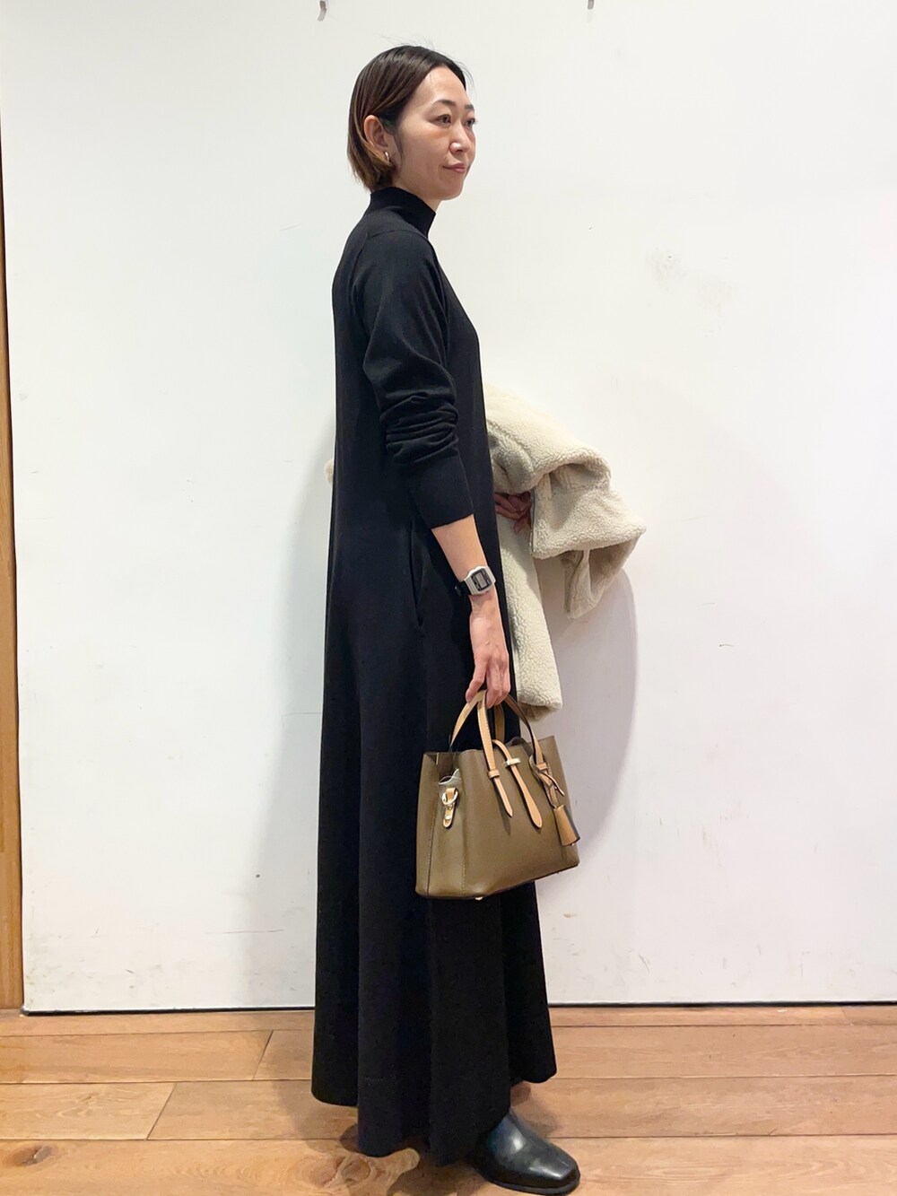 ホワイト系のその他アウター、ブラウン系のハンドバッグ、ブラック系のワンピースを着用したレディースの冬コーディネートの7枚目の写真