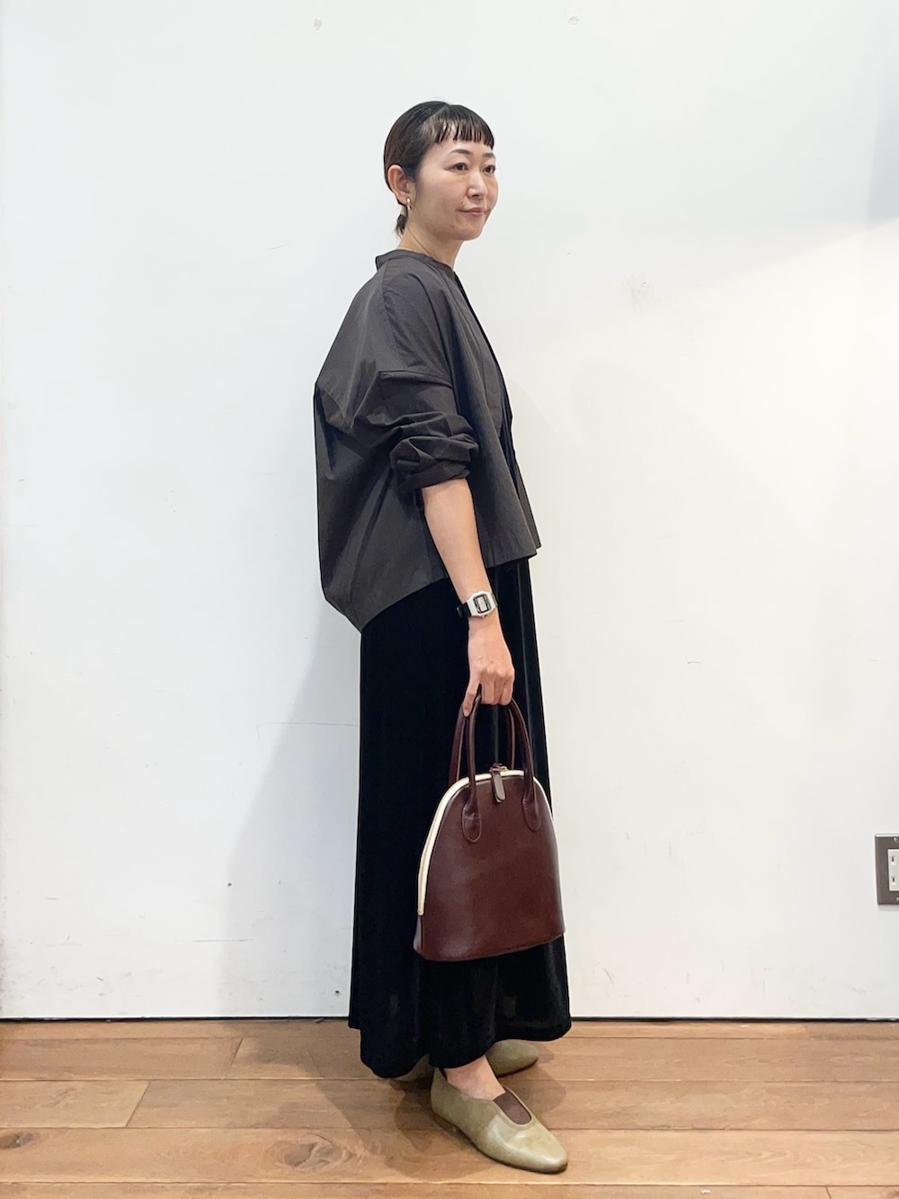 ブラック系のワンピース、ブラウン系のシャツ/ブラウス、レッド系のハンドバッグを着用したレディースの秋コーディネートの3枚目の写真
