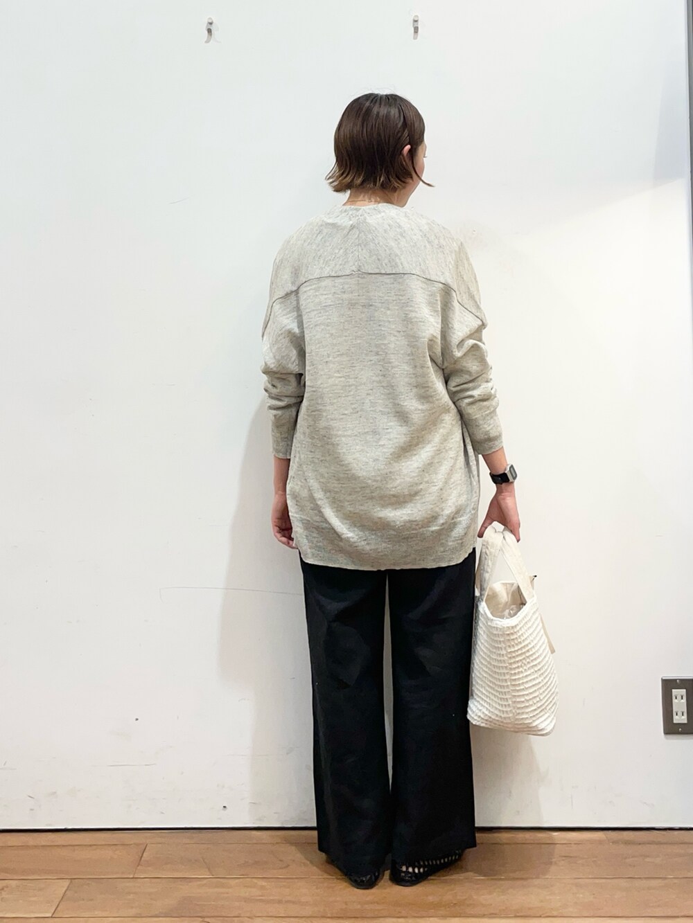 ホワイト系のTシャツ/カットソー、グレー系のカーディガン/ボレロ、ブラック系のサンダルを着用したレディースの春コーディネートの4枚目の写真