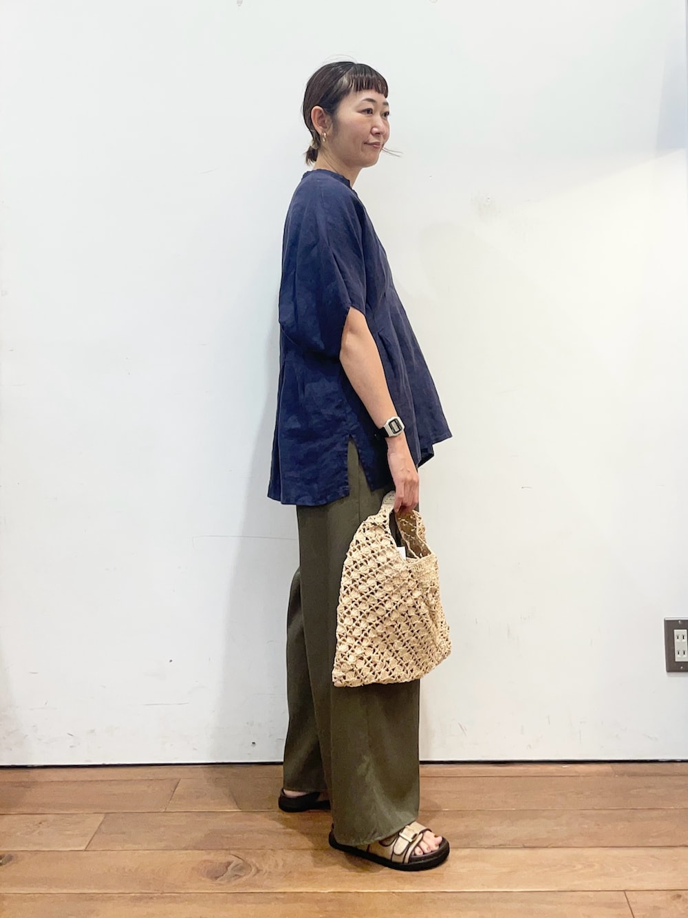 ブルー系のシャツ/ブラウス、グリーン系のその他パンツ、ベージュ系のハンドバッグを着用したレディースの夏コーディネートの3枚目の写真