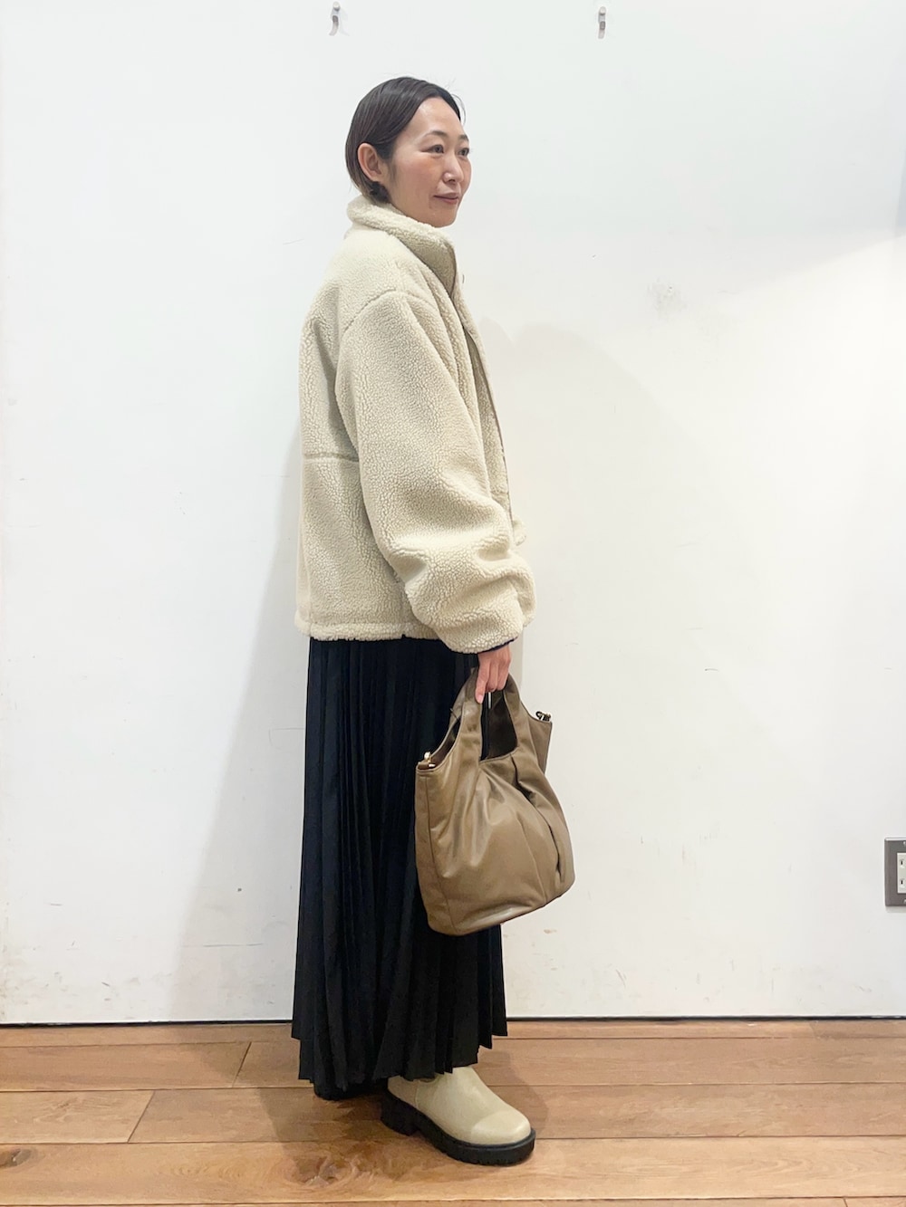 ホワイト系のその他アウター、ブルー系のニット/セーター、ブラック系のスカートを着用したレディースの冬コーディネートの3枚目の写真