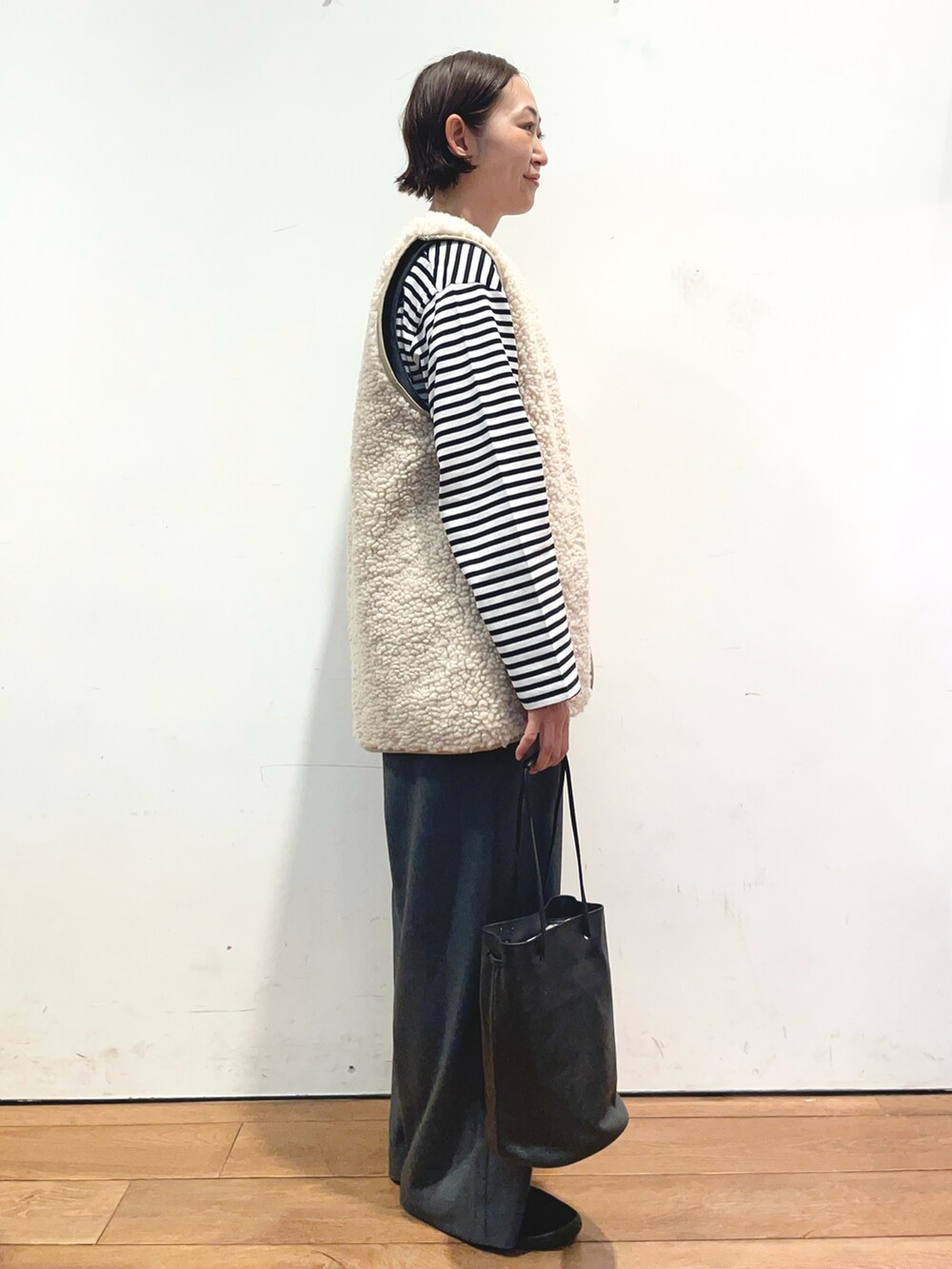 ブラック系のTシャツ/カットソー、ベージュ系のベスト、グレー系のサロペット/オーバーオールを着用したレディースの秋コーディネートの2枚目の写真