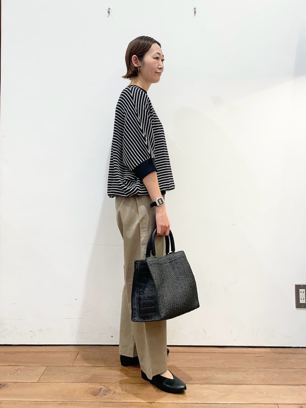 ブラック系のTシャツ/カットソー、ブラック系のパンプス、ブラック系のハンドバッグを着用したレディースの春コーディネートの3枚目の写真