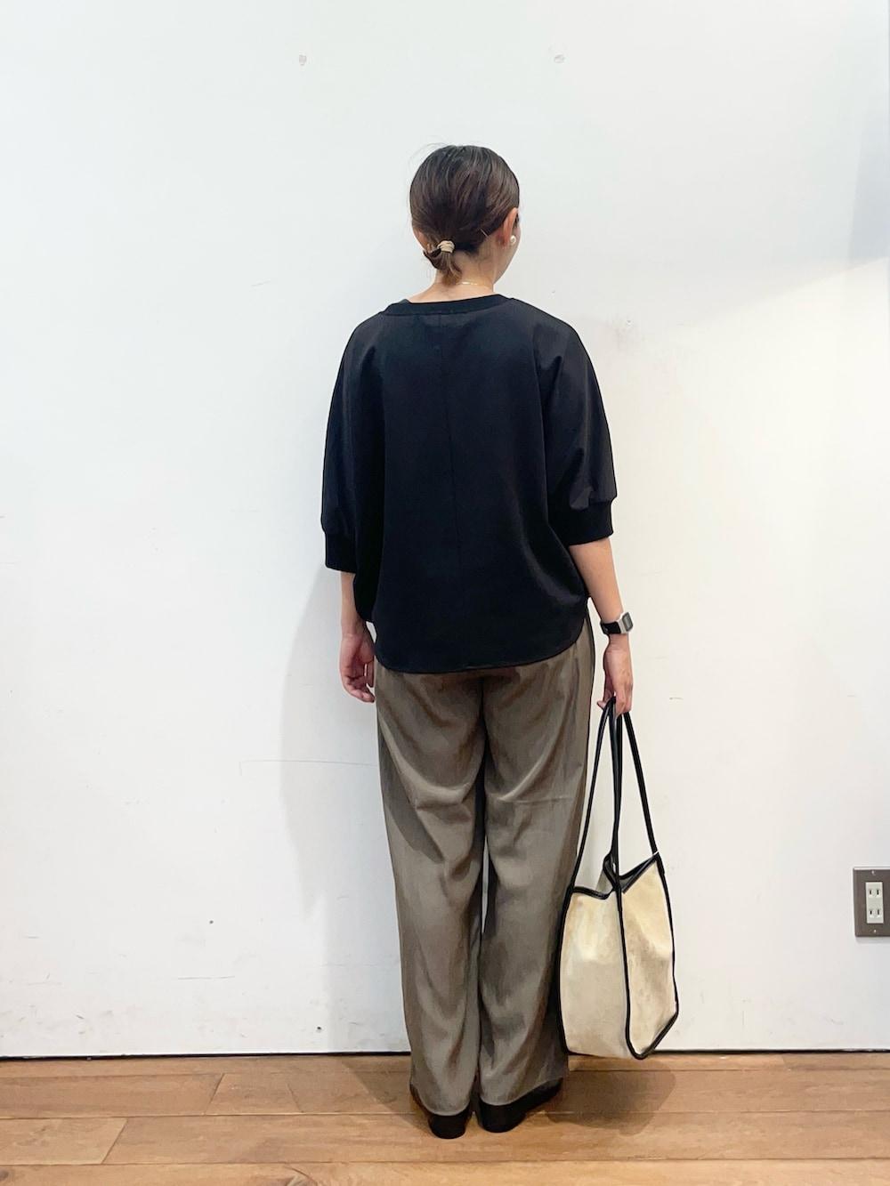 ブラック系のTシャツ/カットソー、ブラウン系のその他パンツ、ベージュ系のトートバッグを着用したレディースの秋コーディネートの4枚目の写真