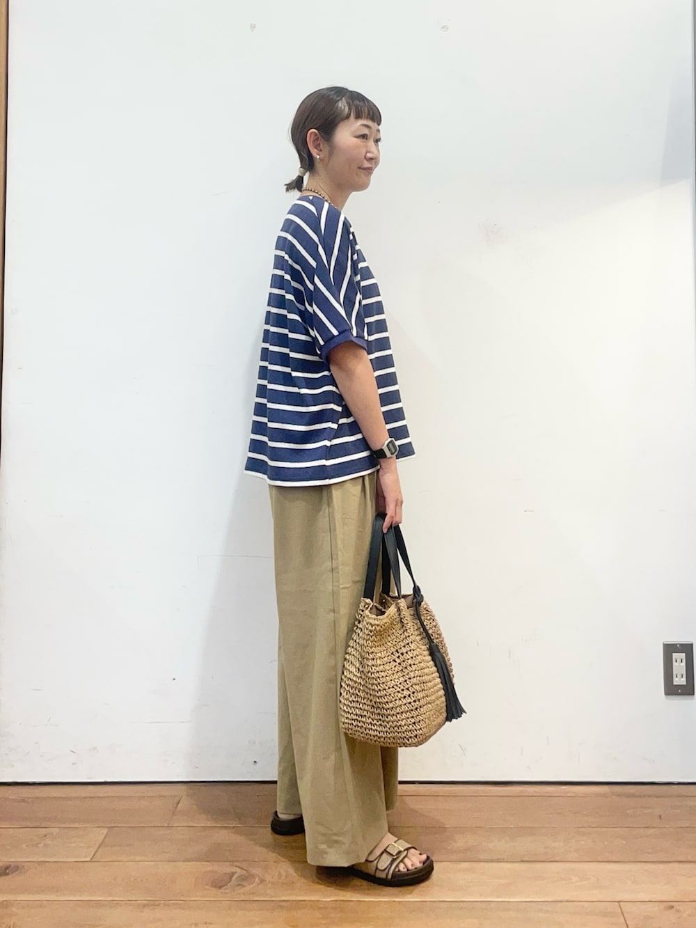 ブルー系のTシャツ/カットソー、ベージュ系のサンダル、イエロー系のかごバッグを着用したレディースの夏コーディネートの3枚目の写真