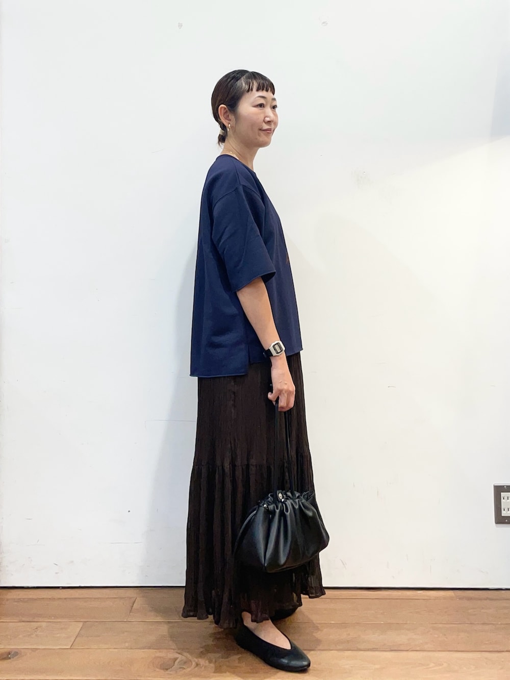 ブルー系のTシャツ/カットソー、ブラウン系のスカート、ブラック系のショルダーバッグを着用したレディースの秋コーディネートの3枚目の写真