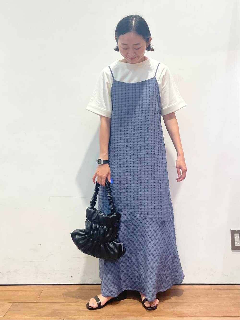 ブラック系のサンダル、ホワイト系のTシャツ/カットソー、ブラック系のハンドバッグを着用したレディースの夏コーディネートの2枚目の写真