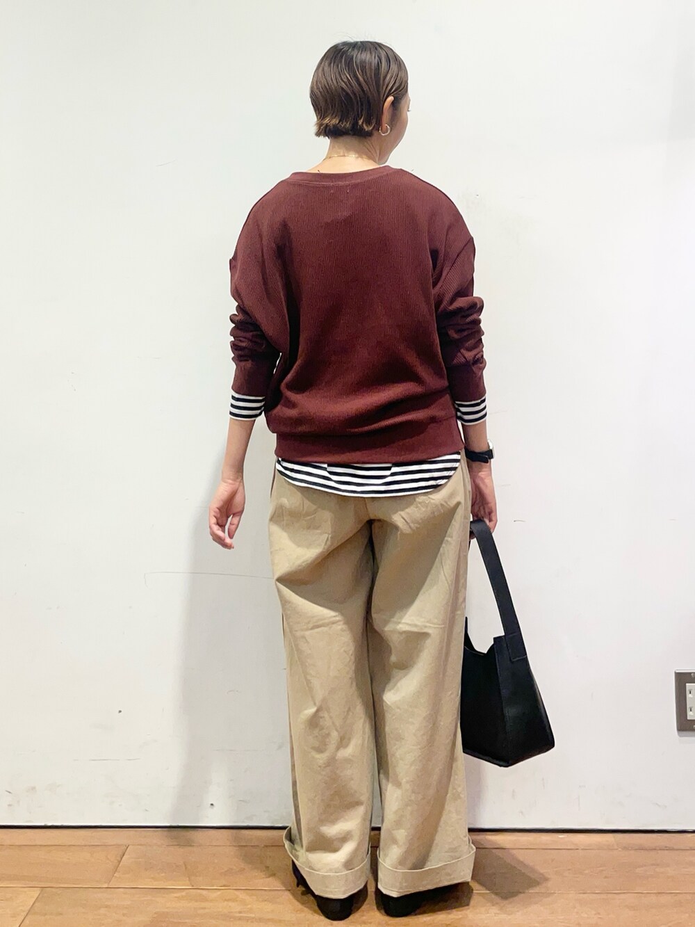 レッド系のカーディガン/ボレロ、ホワイト系のTシャツ/カットソー、ブラック系のハンドバッグを着用したレディースの秋コーディネートの6枚目の写真