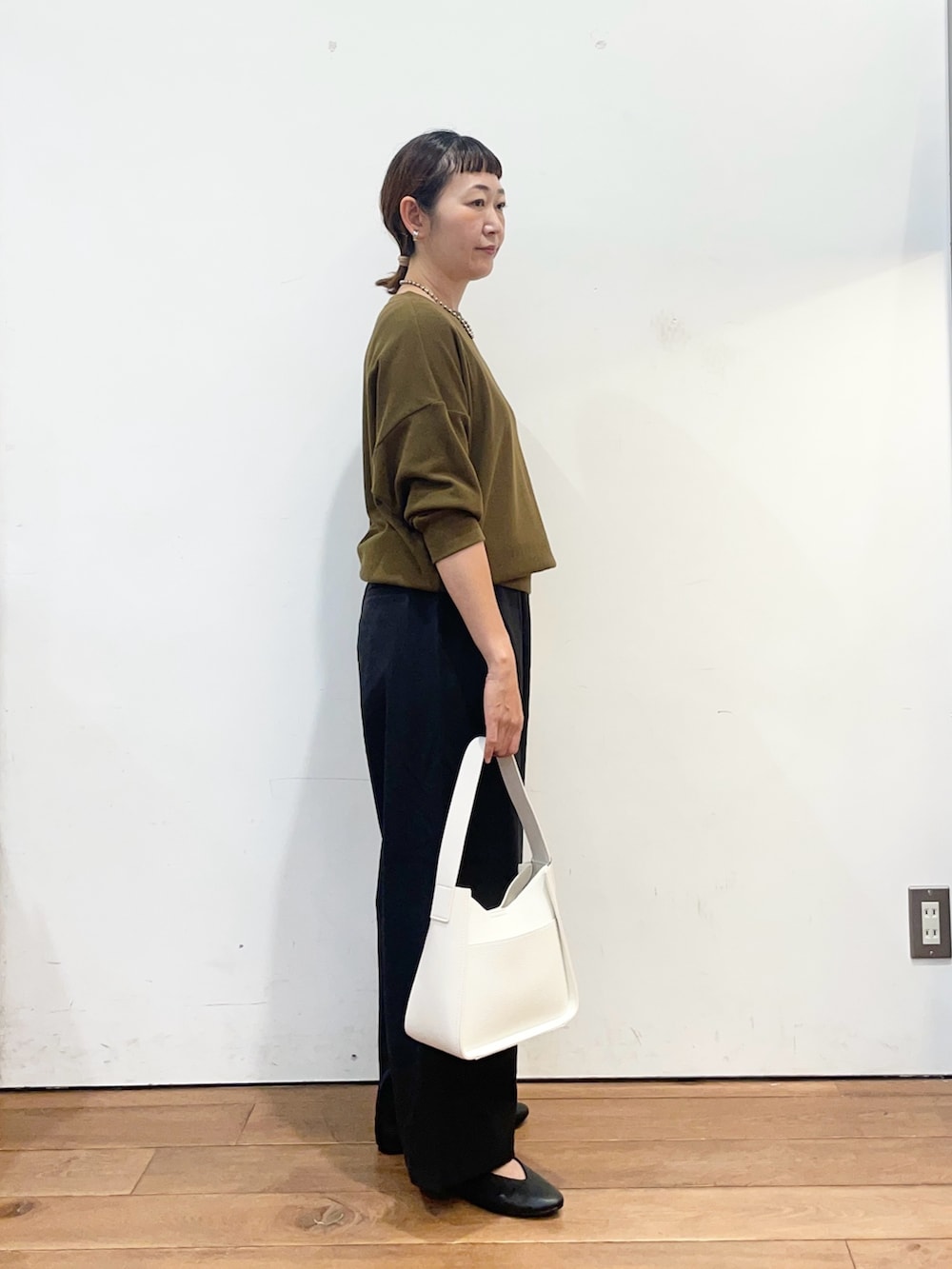 ブラウン系のTシャツ/カットソー、ブラック系のその他パンツ、ホワイト系のハンドバッグを着用したレディースの秋コーディネートの3枚目の写真
