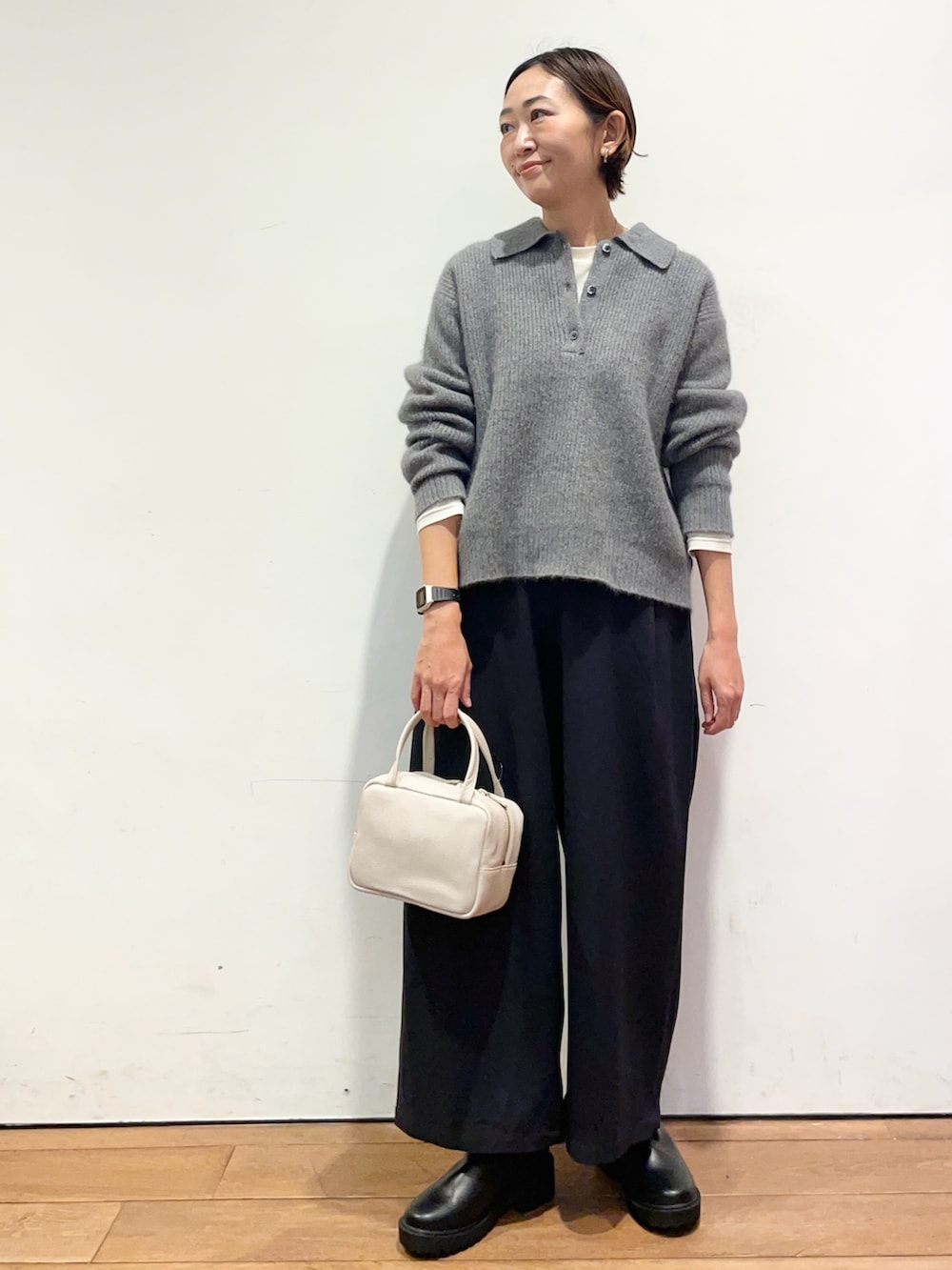 グレー系のニット/セーター、グレー系のボストンバッグ、ブルー系のその他パンツを着用したレディースの秋コーディネートの2枚目の写真