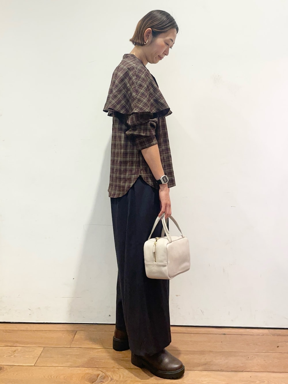 ブラウン系のブーツ、グレー系のボストンバッグ、ブルー系のその他パンツを着用したレディースの秋コーディネートの4枚目の写真