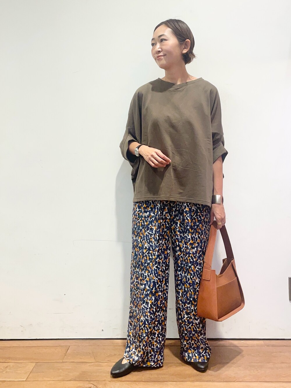グリーン系のTシャツ/カットソー、ブラウン系のハンドバッグ、ブルー系のその他パンツを着用したレディースの夏コーディネートの2枚目の写真