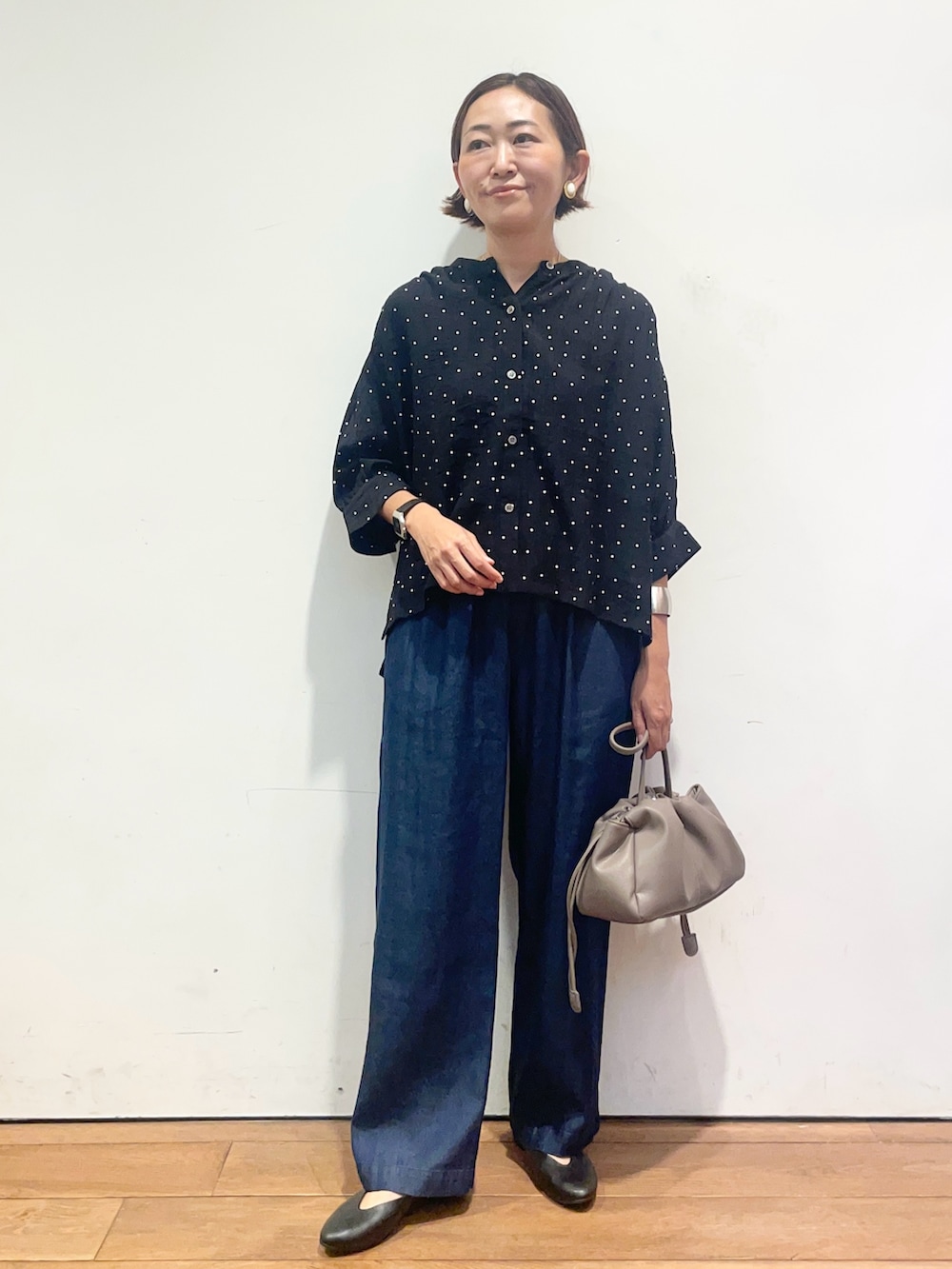 ブラック系のシャツ/ブラウス、ブルー系のデニムパンツ、ベージュ系のショルダーバッグを着用したレディースの夏コーディネートの3枚目の写真