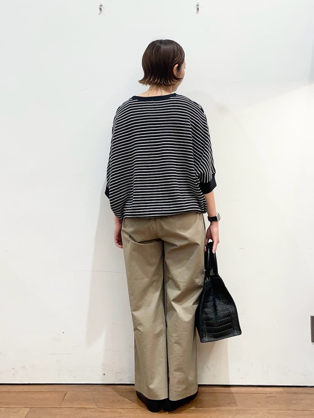 ブラック系のTシャツ/カットソー、ブラック系のパンプス、ブラック系のハンドバッグを着用したレディースの春コーディネートの4枚目の写真
