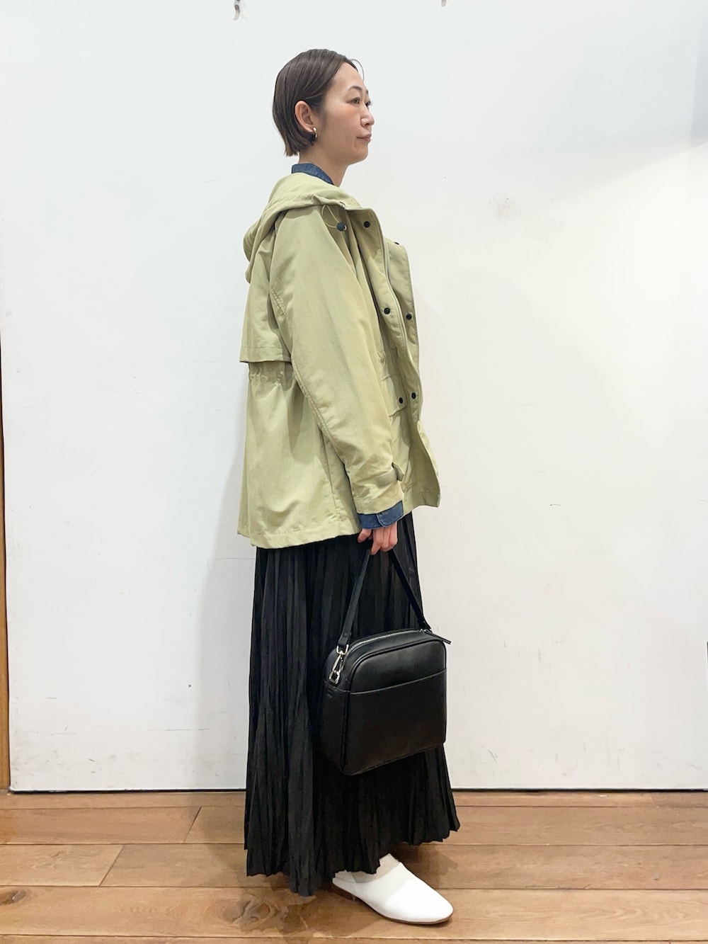 ブルー系のシャツ/ブラウス、グリーン系のマウンテンパーカー、ホワイト系のその他シューズを着用したレディースの春コーディネートの3枚目の写真