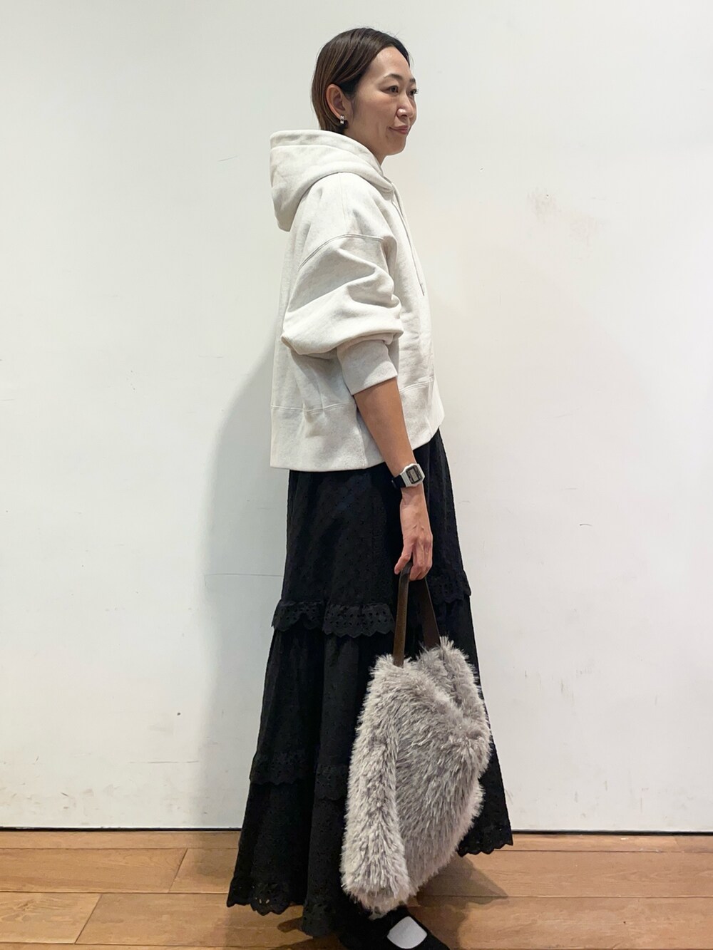 ベージュ系のパーカー、ブラック系のスカート、ブラック系のバレエシューズを着用したレディースの秋コーディネートの4枚目の写真