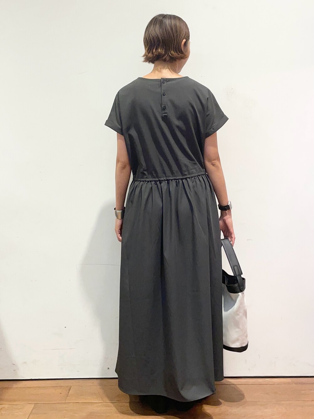 グレー系のワンピース、ブラック系のショルダーバッグを着用したレディースの秋コーディネートの5枚目の写真