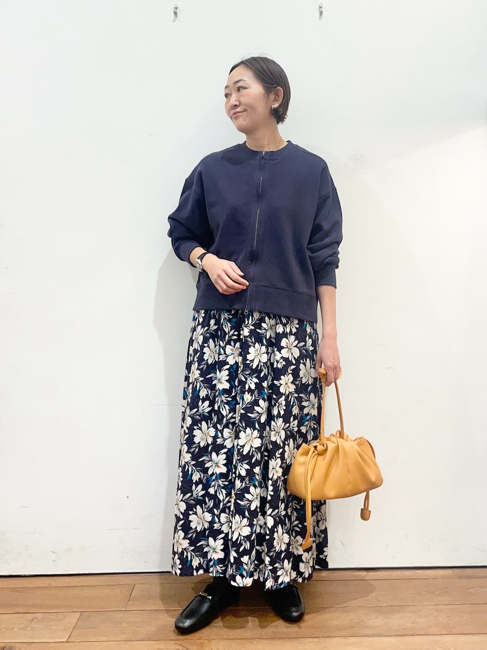 ブルー系のカーディガン/ボレロ、ブルー系のスカート、オレンジ系のショルダーバッグを着用したレディースの春コーディネートの3枚目の写真