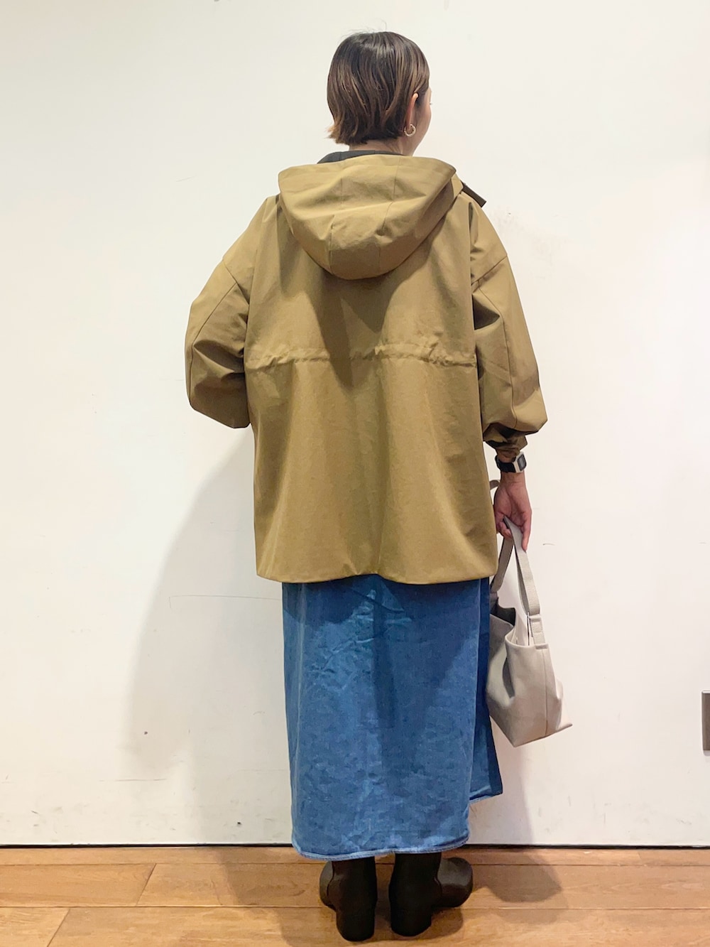 ベージュ系のその他アウター、ブルー系のワンピース、ブラック系のブーツを着用したレディースの秋コーディネートの5枚目の写真