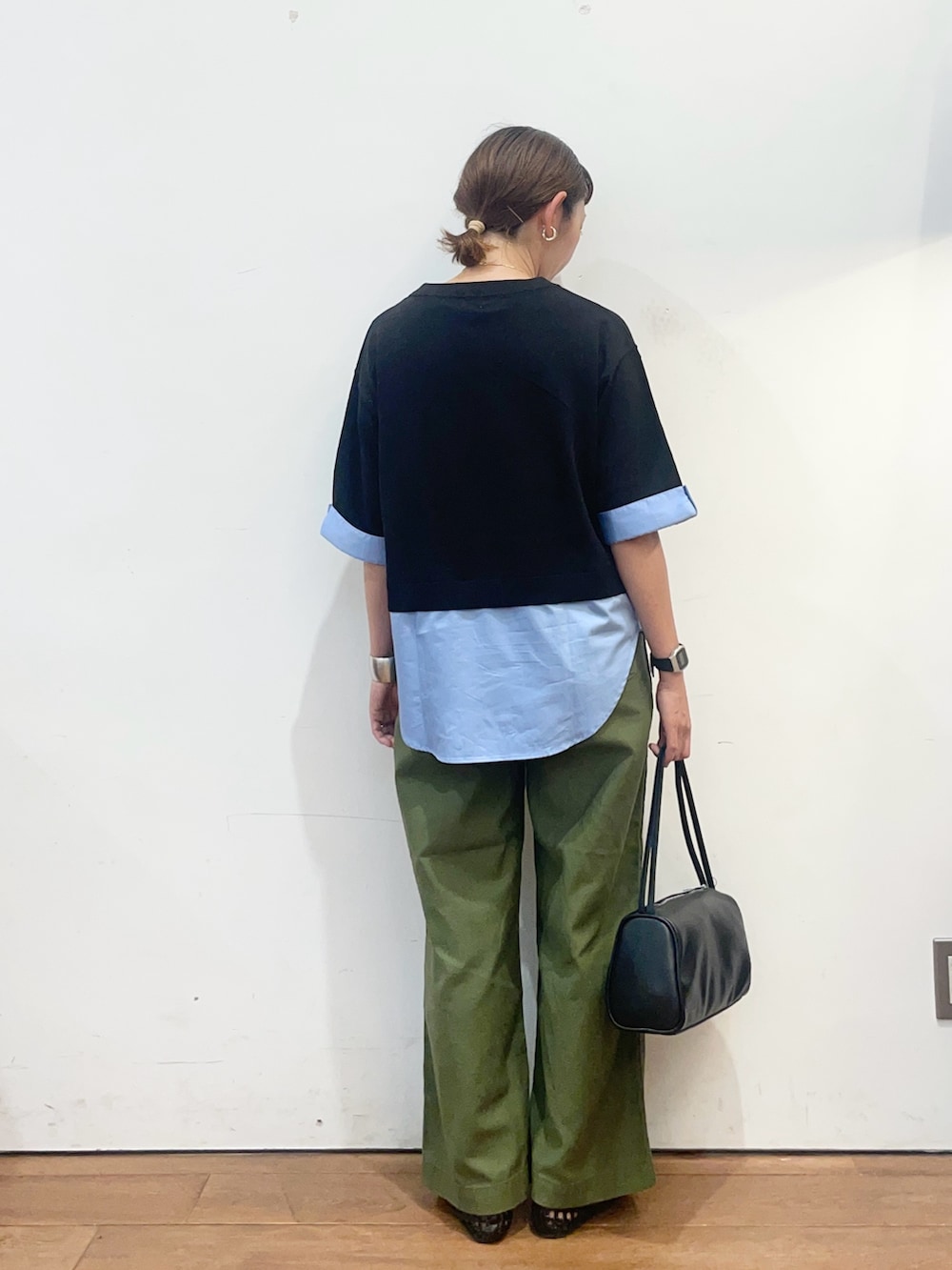ブラック系のニット/セーター、グリーン系のその他パンツ、ブラック系のハンドバッグを着用したレディースの夏コーディネートの5枚目の写真