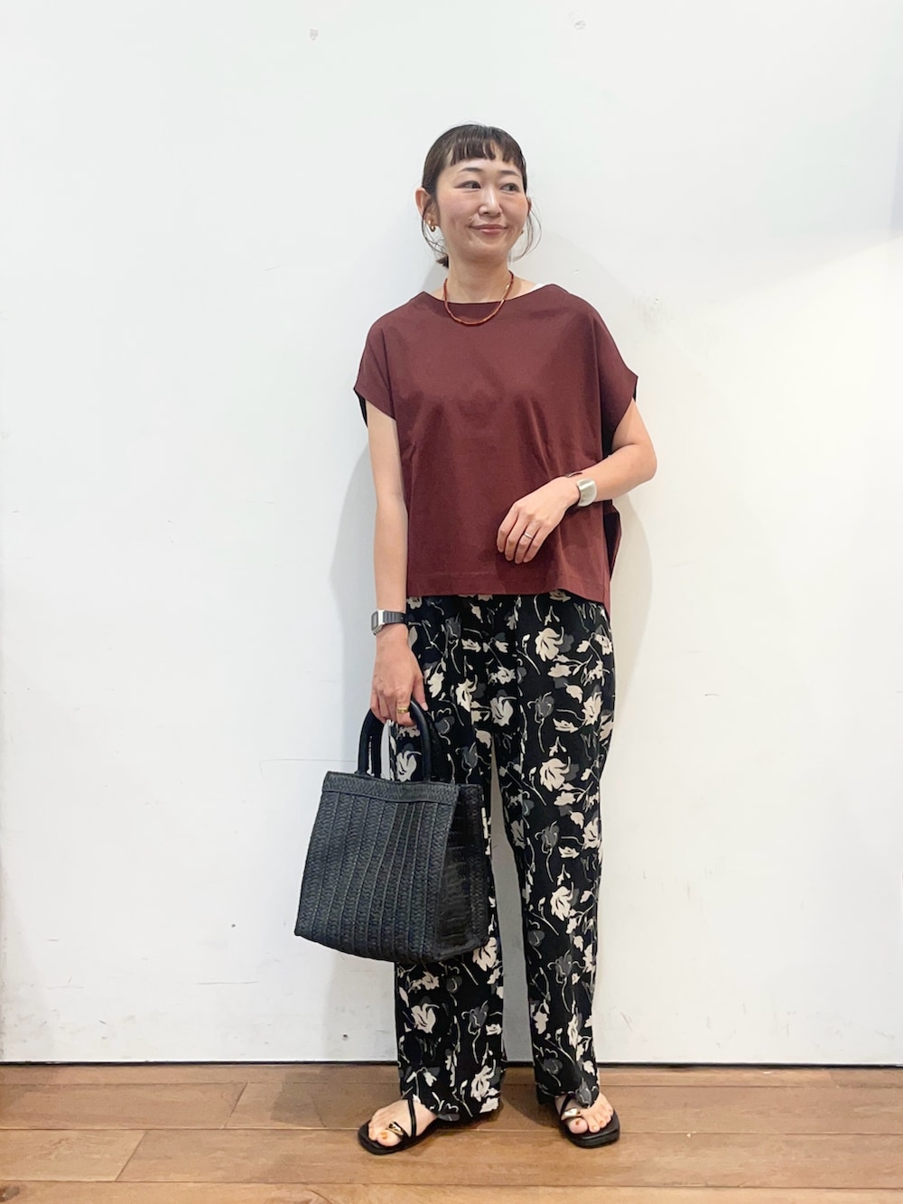 レッド系のTシャツ/カットソー、ブラック系のサンダル、ブラック系のハンドバッグを着用したレディースの夏コーディネートの2枚目の写真